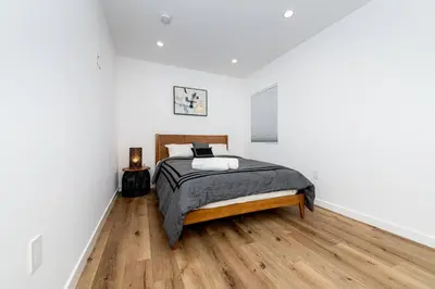 a bedroom with a bed and a wooden floor at NoHo Home Near Universal Studios in Burbank
