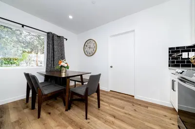 a kitchen with a table and chairs and a clock on the wall at NoHo Home Near Universal Studios in Burbank