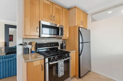 a kitchen with a stove and a microwave at The Andalusite - Oceanfront Steps from the Sand in Los Angeles