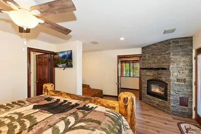 a bedroom with a bed and a stone fireplace at Recreation Ridge-Next To Boulder Bay-HUGE in Big Bear Lake
