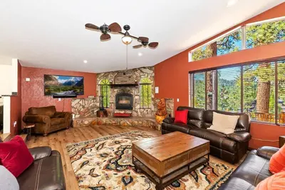 a living room with a stone fireplace and leather furniture at Recreation Ridge-Next To Boulder Bay-HUGE in Big Bear Lake