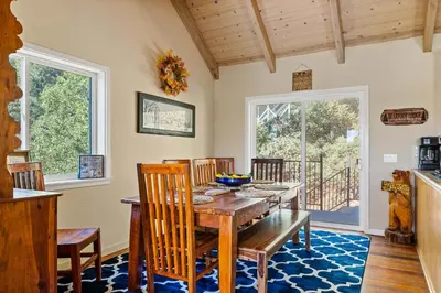 a dining room with a wooden table and chairs at Bearfoot Lodge near Hiking & Skiing in Lake Arrowhead