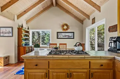 a kitchen with a stove top oven in a room at Bearfoot Lodge near Hiking & Skiing in Lake Arrowhead