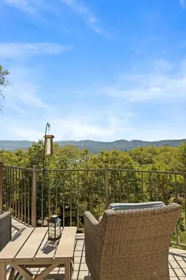a patio with a wooden table and chairs on a balcony at Bearfoot Lodge near Hiking & Skiing in Lake Arrowhead