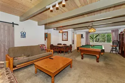 a living room with a couch and a pool table at Bow N Arrow Lodge For 8 in Lake Arrowhead