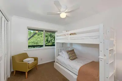 a bedroom with a bunk bed and a chair at Casa Del Lago - Spacious 4 Story Gated Home in Lake Arrowhead