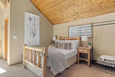 a bedroom with a wooden bed and a wooden ceiling at Chalet Vino - Snow Valley Mountain Resort in Green Valley Lake