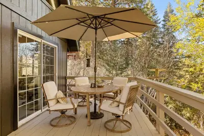 a patio with a table and chairs and an umbrella at Chalet Vino - Snow Valley Mountain Resort in Green Valley Lake
