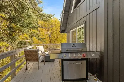 a grill on a deck next to a house at Chalet Vino - Snow Valley Mountain Resort in Green Valley Lake