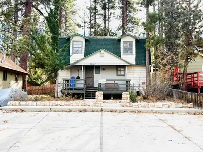 a green and white house with a driveway at Happy Bear Cabin - Hike Bike & More in Big Bear Lake