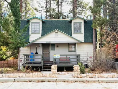a house with a bench in front of it at Happy Bear Cabin - Hike Bike & More in Big Bear Lake