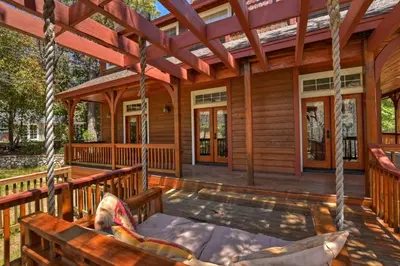 a porch of a log cabin with swings at Matternhorn Peak Lodge - For 10 in Lake Arrowhead