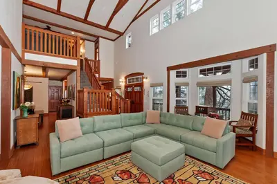 a living room with a green couch and a table at Matternhorn Peak Lodge - For 10 in Lake Arrowhead