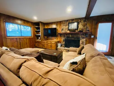 a living room with a large couch and a fireplace at Our Secret Getaway - Two Spacious Living Areas in Lake Arrowhead