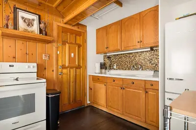a kitchen with wooden cabinets and white appliances at Pineland Getaway - Serene Escape in Green Valley Lake