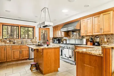 a large kitchen with wooden cabinets and white appliances at Summit Pine Lodge - 2 Minutes to Snow Summit in Big Bear Lake
