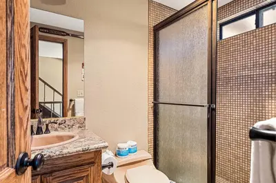 a bathroom with a shower and a toilet and a sink at The Adler's Nest - Lakefront with Pool Spa and Summer Dock in Big Bear Lake