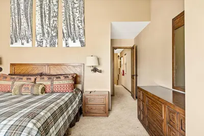 a bedroom with a bed and a dresser and a mirror at The Adler's Nest - Lakefront with Pool Spa and Summer Dock in Big Bear Lake