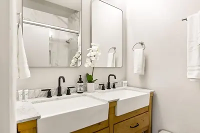 a white bathroom with two sinks and a mirror at The Fancy Fox - Stunning 4 BR Retreat Close to Lake in Lake Arrowhead