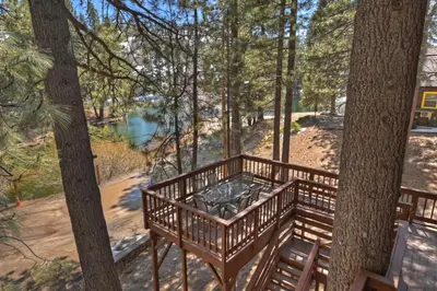 a bench in the woods with a view of a river at Tres Patos - Lakefront Stay for 8 in Green Valley Lake