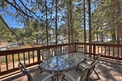 a patio with a table and chairs on a deck at Tres Patos - Lakefront Stay for 8 in Green Valley Lake