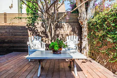 a blue table with a potted plant on a wooden deck at Venice 2BR - Ocean Walk with Stunning Outdoor Space! in Los Angeles