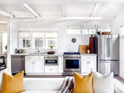 a kitchen with white cabinets and a couch at Venice 2BR - Ocean Walk with Stunning Outdoor Space! in Los Angeles
