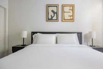 a bedroom with a large white bed with two lamps at Blueground Venice pool AC nr beach LAX-1330 in Los Angeles