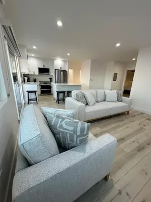 a living room with two couches and a kitchen at Manhattan Beach Modern Panoramic Sea View in Manhattan Beach