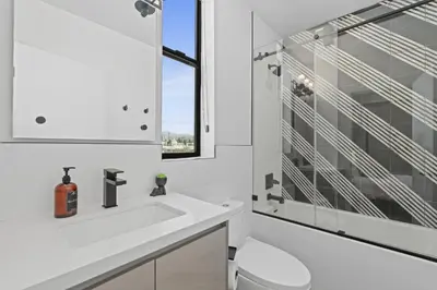 a white bathroom with a sink and a mirror at Serene Hollywood in Los Angeles
