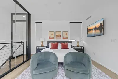 a bedroom with a bed and two chairs at Serene Hollywood in Los Angeles