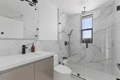 a white bathroom with a toilet and a shower at Serene Hollywood in Los Angeles
