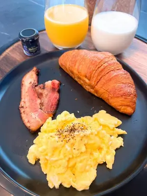 a plate of food with eggs ham and bread and orange juice at Boy Travel in Hewitt