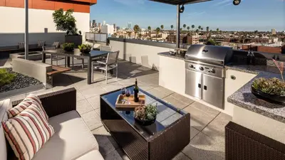 an outdoor patio with tables and a kitchen on a roof at Heart of Koreatwon, 1Bed Studio in Los Angeles