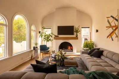 a living room with a couch and a fireplace at Hauser House, Modern Artful Spanish-style Bungalow in Los Angeles