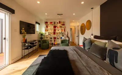 a living room with a large bed and a couch at Hauser House, Modern Artful Spanish-style Bungalow in Los Angeles