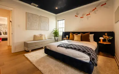 a bedroom with a large bed and a couch at Hauser House, Modern Artful Spanish-style Bungalow in Los Angeles
