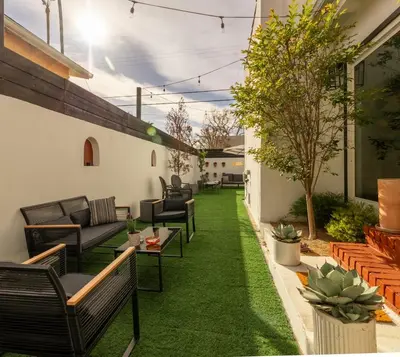 a patio with chairs and a green lawn at Hauser House, Modern Artful Spanish-style Bungalow in Los Angeles