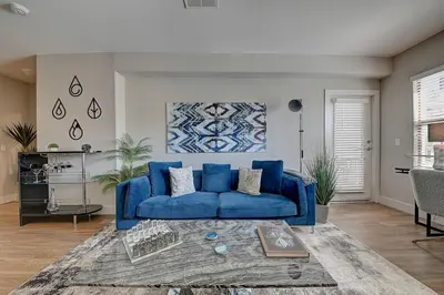 a blue couch in a living room with a table at Sexy One Bedroom Apartment - Pool View & Parking in Los Angeles