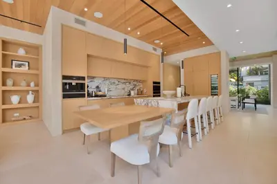 a kitchen with a wooden table and white chairs at Hutton Villa in Los Angeles