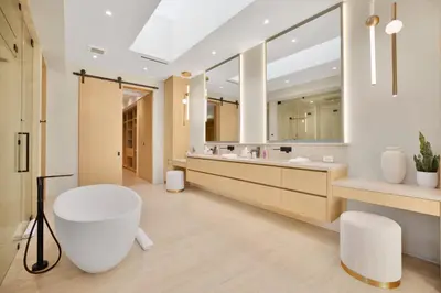 a bathroom with a tub and a large mirror at Hutton Villa in Los Angeles