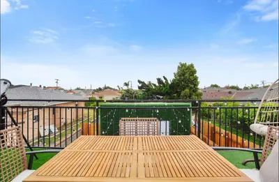 a wooden table and two chairs on a balcony at Twilight Terrace - Telescope - 15 Min to Beach in Hawthorne