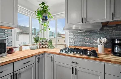 a kitchen with white cabinets and a stove top oven at Twilight Terrace - Telescope - 15 Min to Beach in Hawthorne