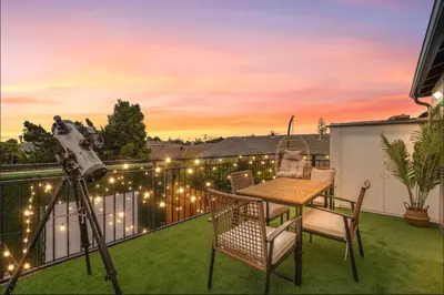 a camera on a balcony with a table and chairs at Twilight Terrace - Telescope - 15 Min to Beach in Hawthorne
