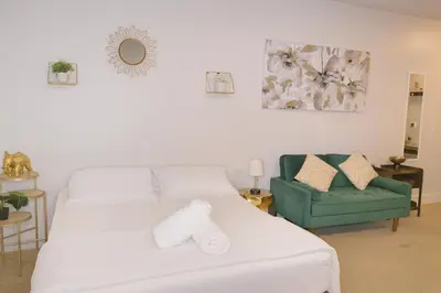 a bedroom with two beds and a green chair at Deluxe Living in Marina Del Rey - Pool, Hot Tub, Gym in Los Angeles