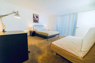 a bedroom with two beds and a desk and a lamp at Western and Santa Monica in Los Angeles