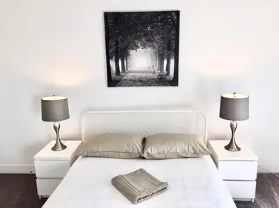 a bedroom with a white bed with two lamps at Western and Santa Monica in Los Angeles
