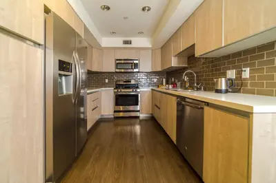 a large kitchen with wooden floors and stainless steel appliances at Western and Santa Monica in Los Angeles