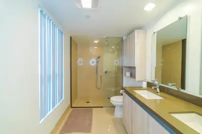 a bathroom with a shower and two sinks and a toilet at Western Santa Monica in Los Angeles