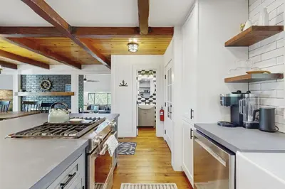 a kitchen with white walls and wooden ceilings at The Kingsview Lakehouse in Lake Arrowhead